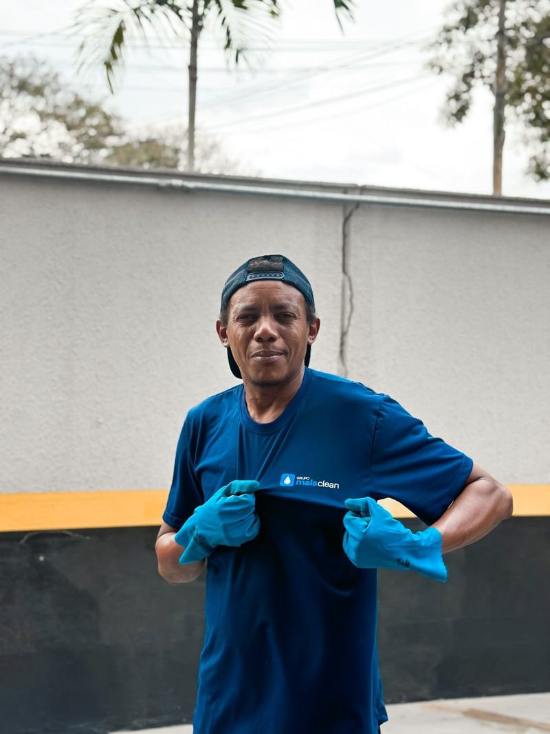 Colaborador de boné e luvas mostrando o bordado da camisa do Grupo Mais Clean