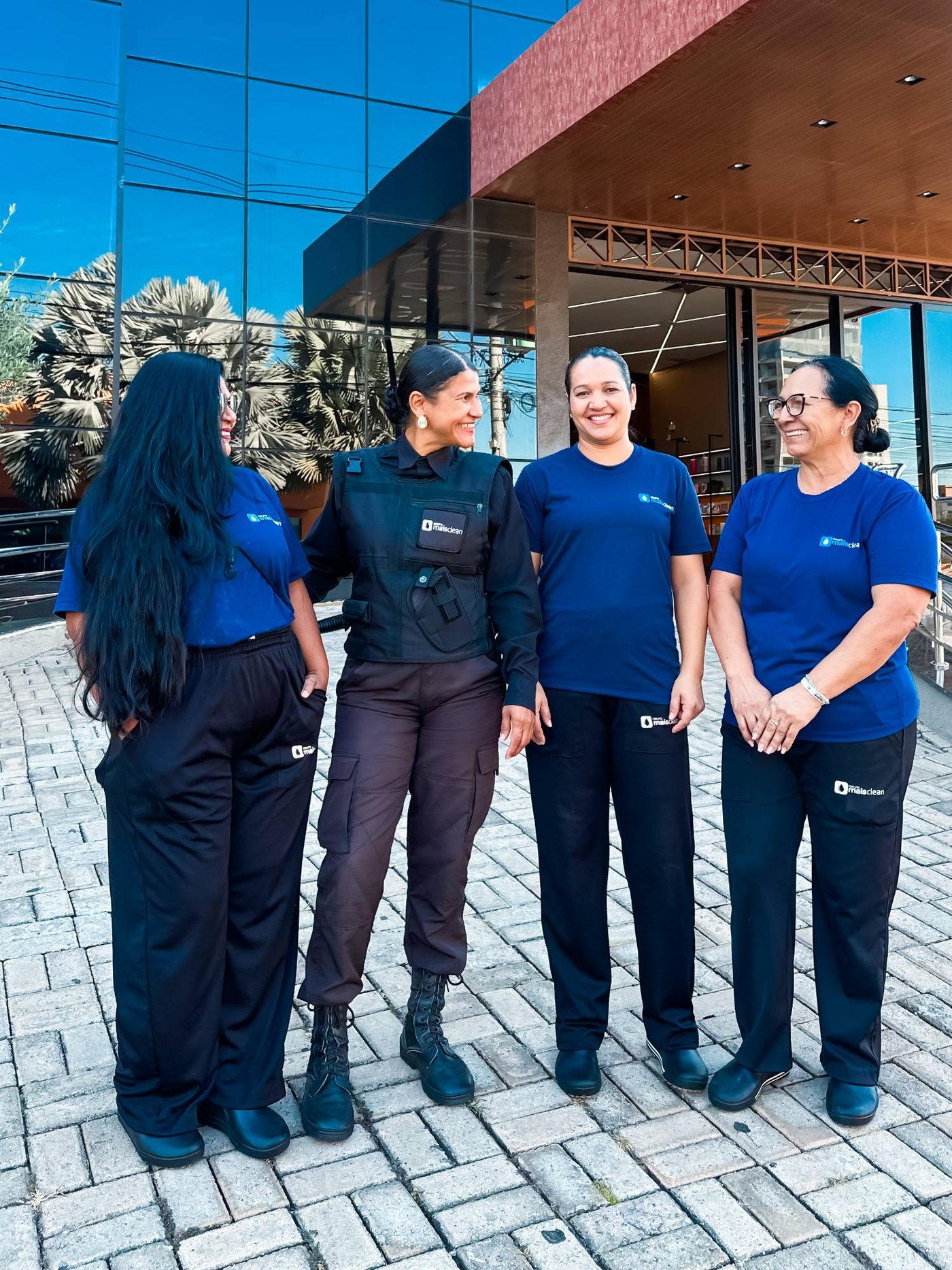 Colaboradoras do Grupo Mais Clean, uma delas da portaria, em frente a um prédio