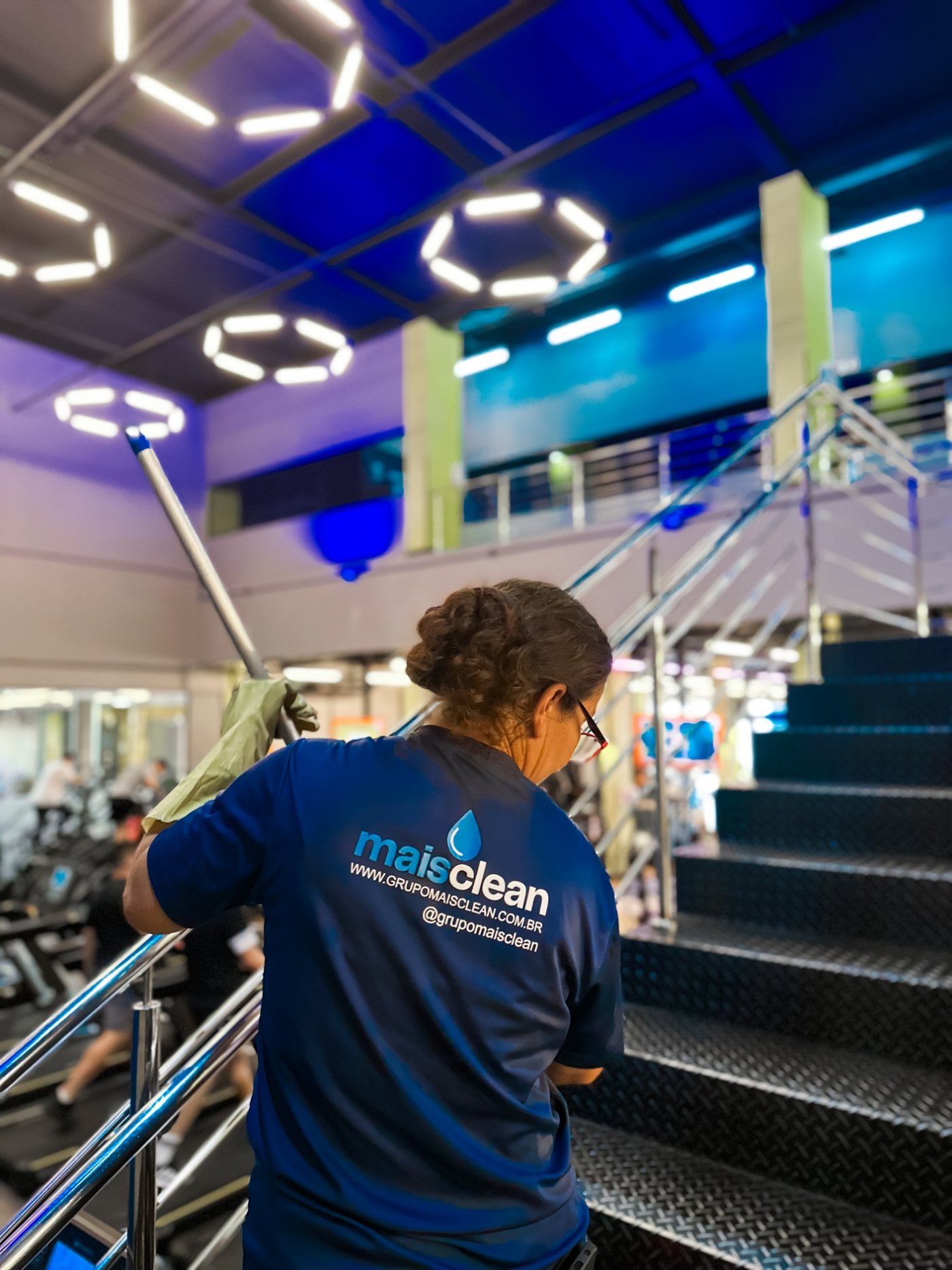 Colaboradora do Grupo Mais Clean limpando a escada de uma academia
