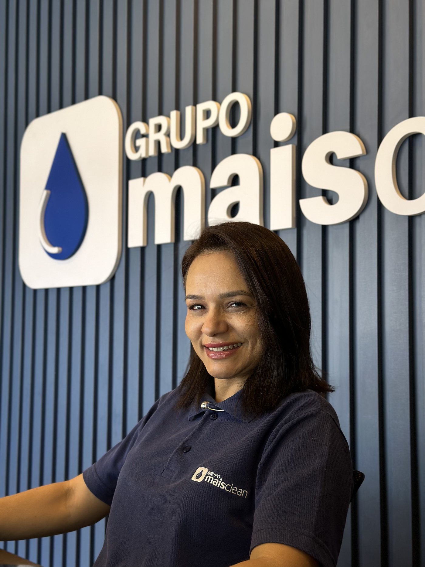 Colaboradora do Grupo Mais Clean sorrindo na sede da empresa